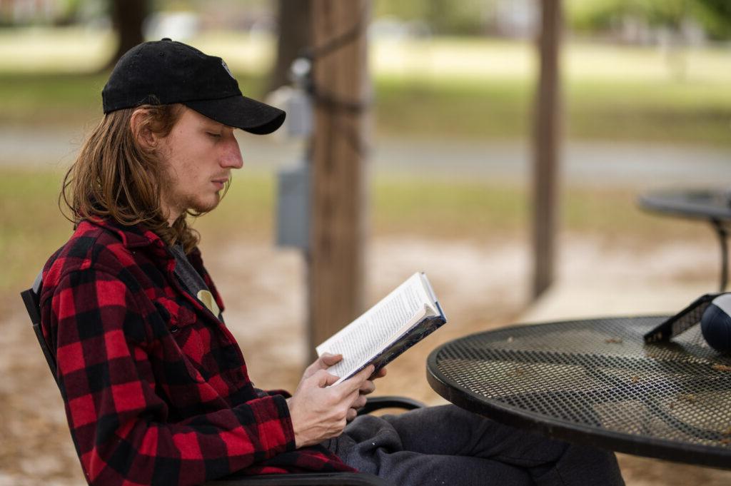 student reading a book outside